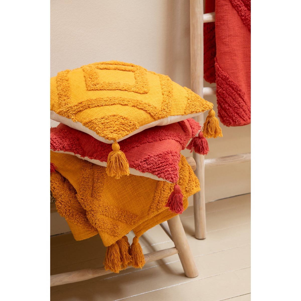 Quadratisches Kissen mit Quasten und Muster – Ocker Boho Design