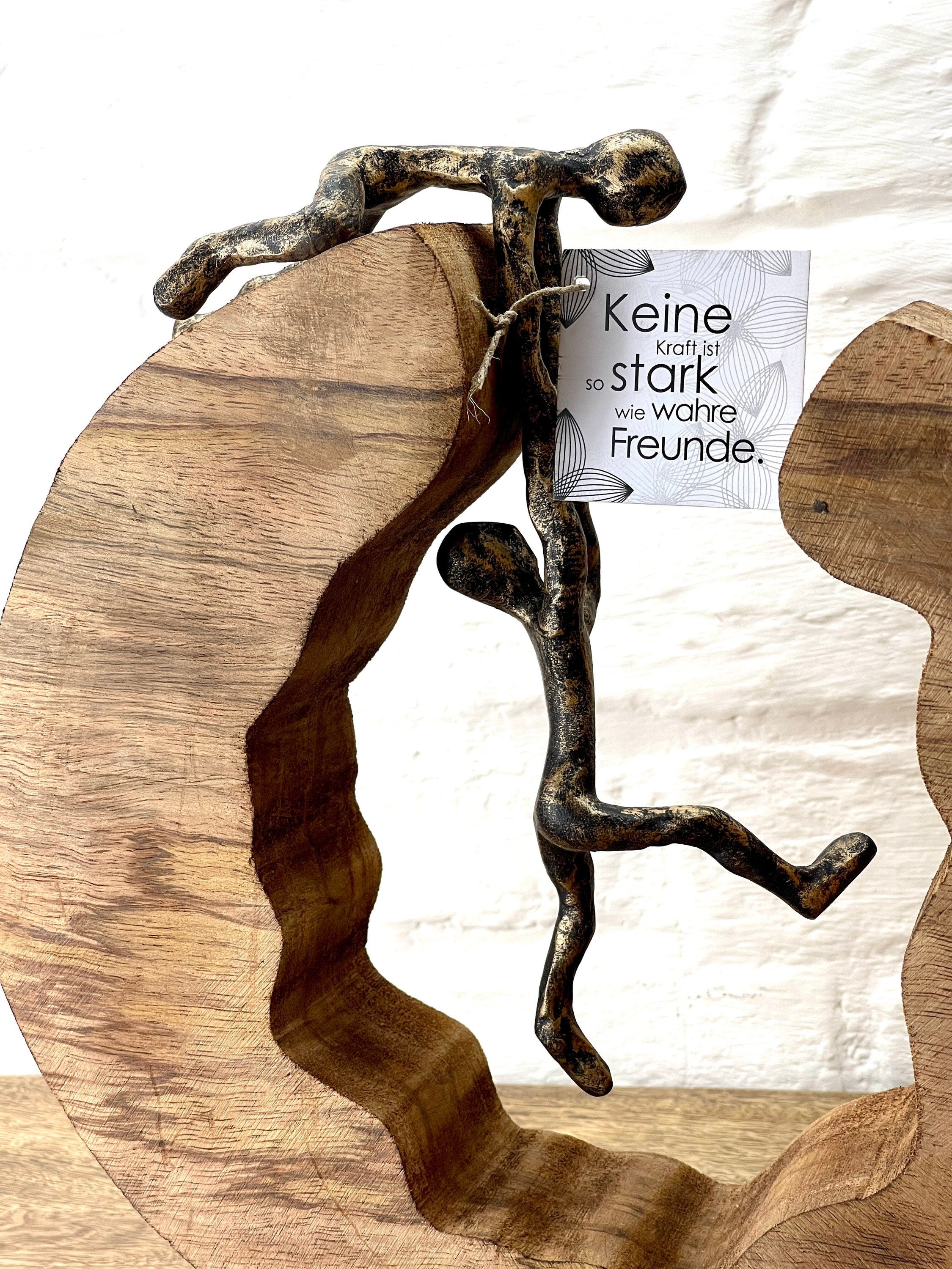 Bronzefarbene Skulptur Teamwork Symbol für Zusammenarbeit und Freundschaft