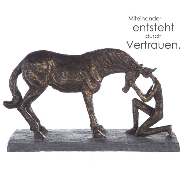 Skulptur Comprehension - Bronzefarbene Darstellung eines Pferds mit Reiterin auf grauer Basis inklusive Spruchanhänger