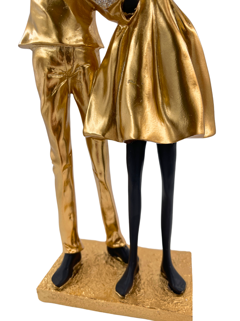 Elegant sculpture of a couple in black and gold with heart shiny
