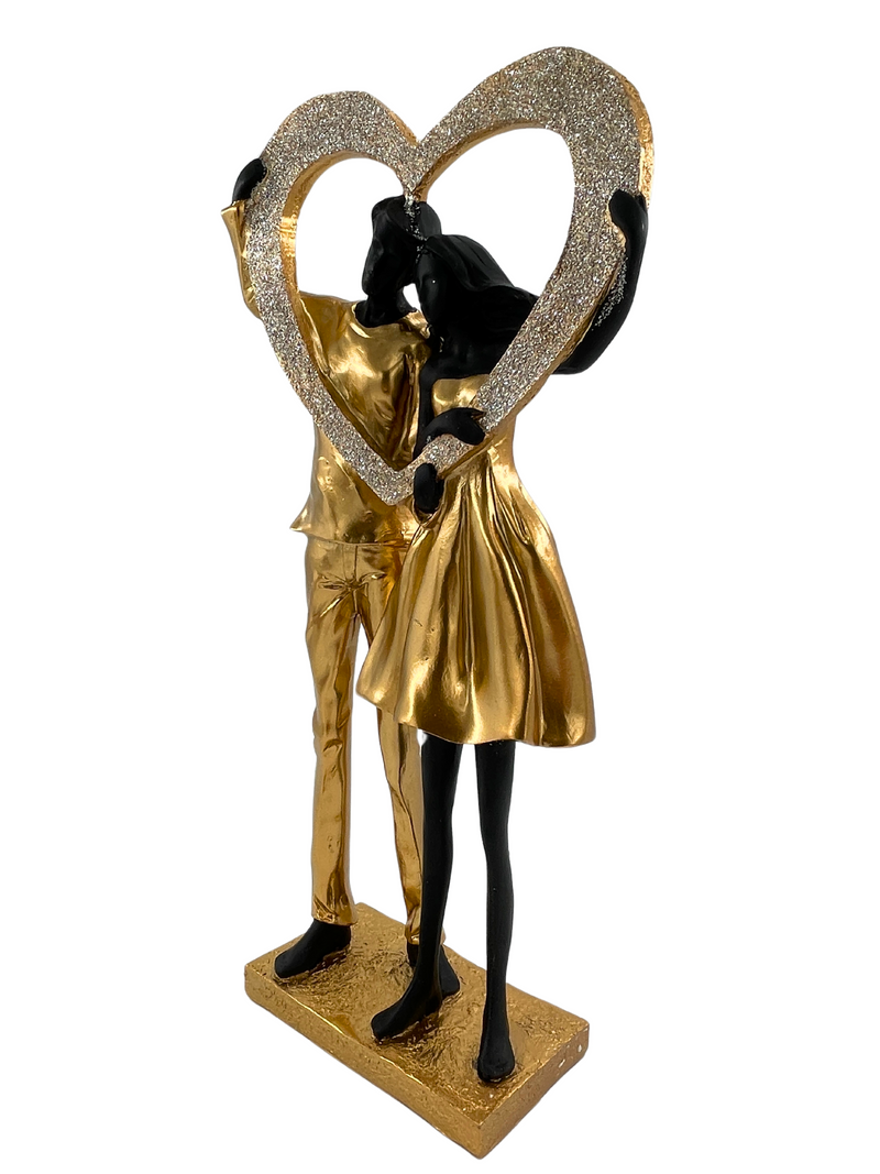 Elegant sculpture of a couple in black and gold with heart shiny
