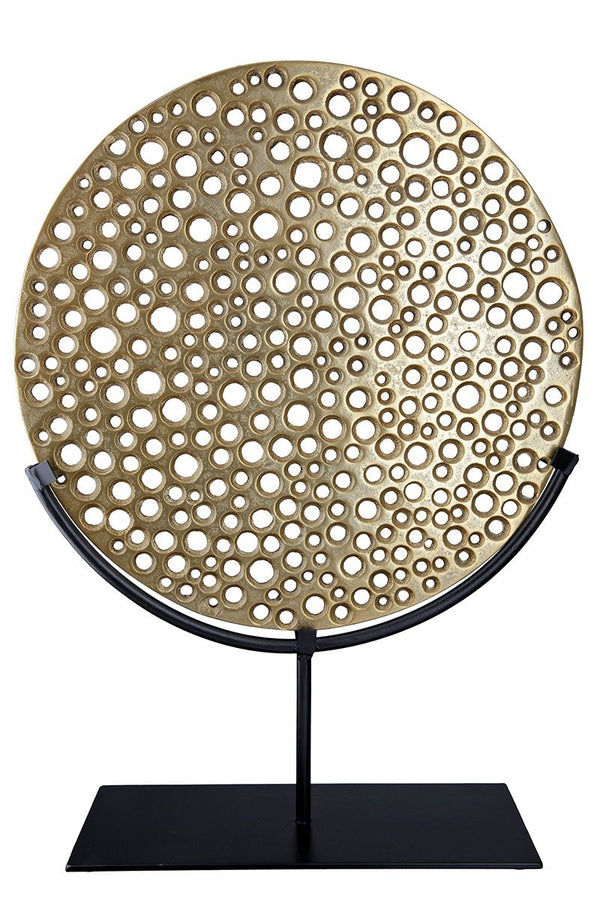 Hive - Goldfarbenes, gelochtes Objekt auf schwarzem Metallständer von GILDE